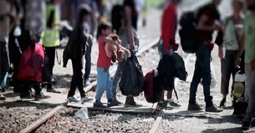 Photo of different aged people on foot crossing the tracks