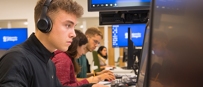 Student sitting at PC with headphones