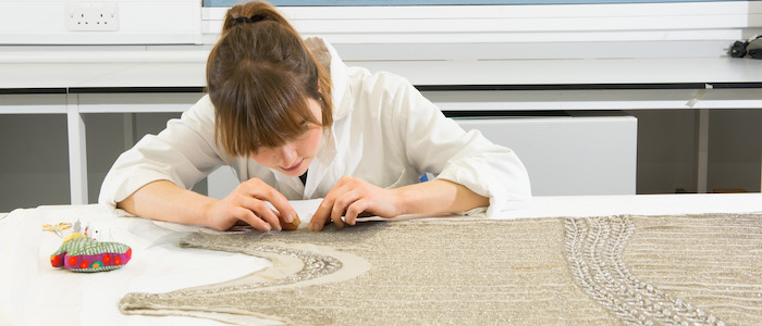 Student working on a dress in the conservation lab
