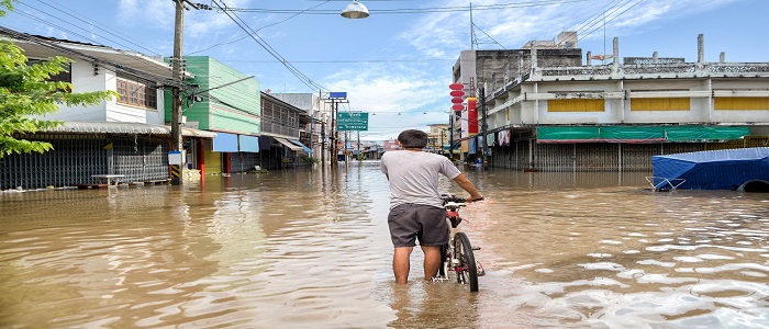 Boy standing in a street filled with rain water