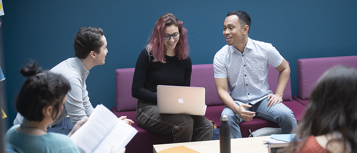 Dumfries study group against a blue wall 