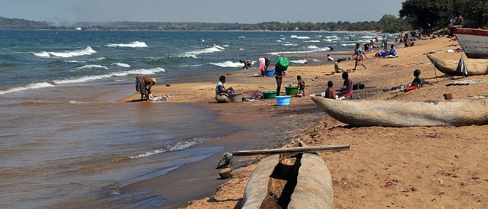 Women and children washing clothes on the shoreline