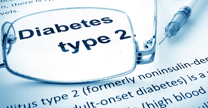 An artistic image that shows Diabetes Type 2 printed on a paper and kept alongwith glasses and a syringe.