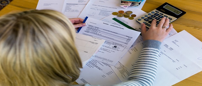 Women sitting with lots of bills in front of her 