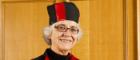 Senior female professor wearing graduation gown and hat