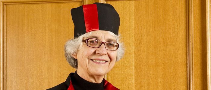 Senior female professor wearing graduation gown and hat