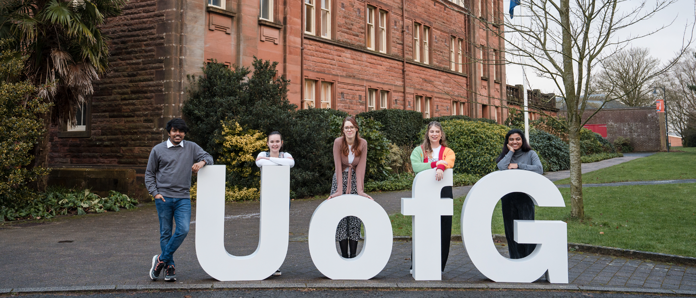 4 students behind big UofG letters