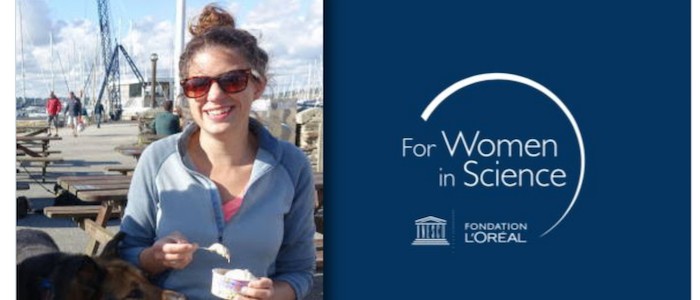 Image of Dr Christina Faust outdoors with L'oreal-UNESCO awards arwork