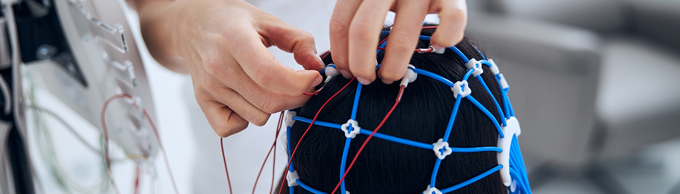 Doctor preparing the woman in a silicone cap for the EEG