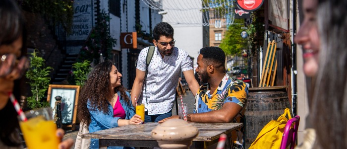 Students chatting and enjoying Ashton Lane near the University of Glasgow