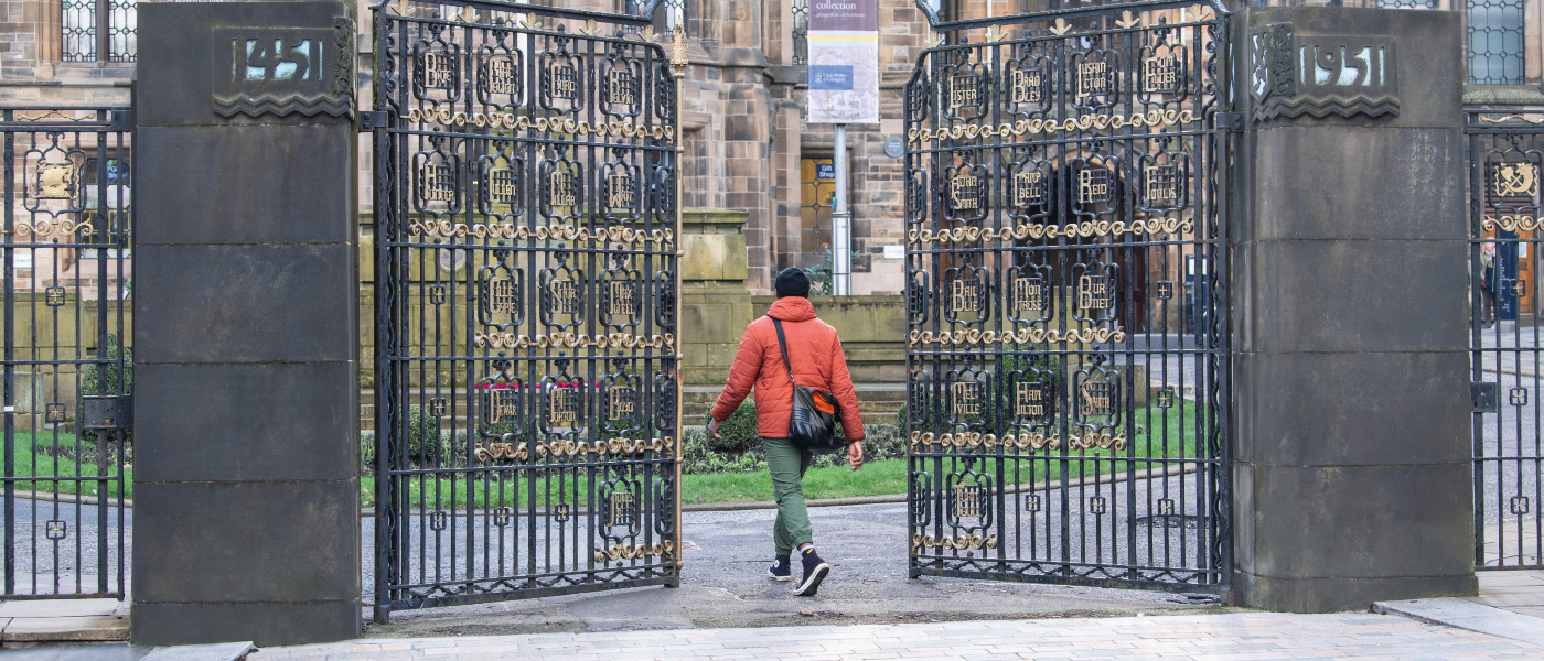 A student entering the Gilmorehill Campus via the memorial gate