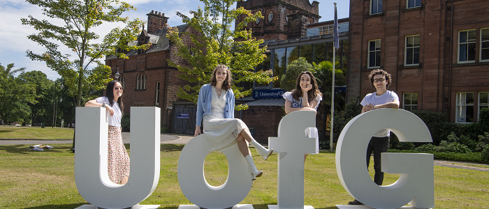 Students standing with large letters saying U of G