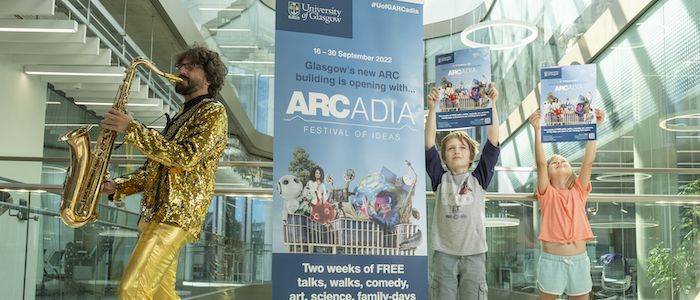 Luca Nelli, saxophone player for brass band Brass, Aye? and research associate from the University of Glasgow’s Institute of Biodiversity Animal Health & Comparative Medicine, joins local children Elliot James and Elsie Tyler to celebrate the launch of the ARCadia Festival of Ideas at the Mazumdar-Shaw Advanced Research Centre