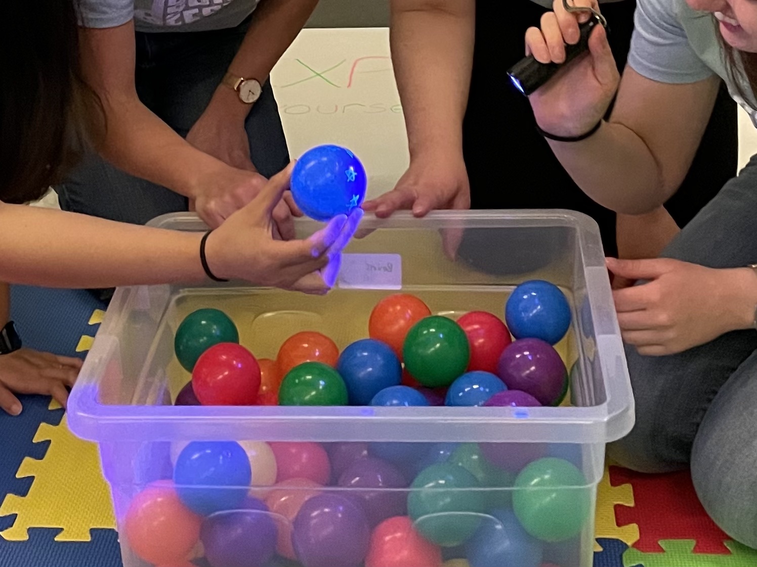 A clear plastic box with multicoloured play balls