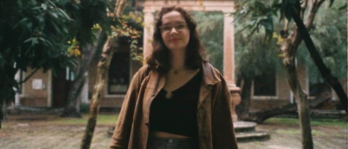 Head and torso of a young female standing in front of an archway