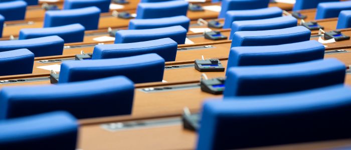 Rows of empty blue seats in a parliament hall