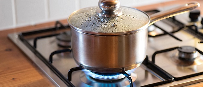 A small metal cooking pot on a gas ring on a cooker. Steam is condensing on the glass lid of the pot. Source: iStockPhoto | Stadtratte https://www.istockphoto.com/photo/a-pot-on-a-stove-gm849900930-139534677