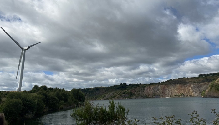 Wind turbine on a hill next to a lake (loch) with steep sides. Source: Ewan Gibbs, 2021