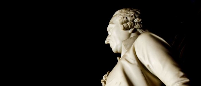 Adam Smith marble statue against a black background