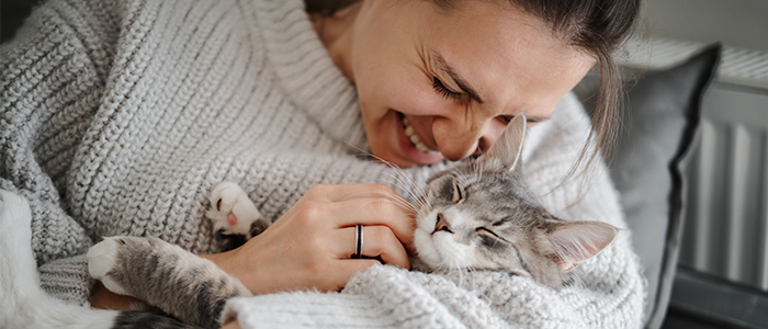 Happy woman snuggling into her sleeping cat