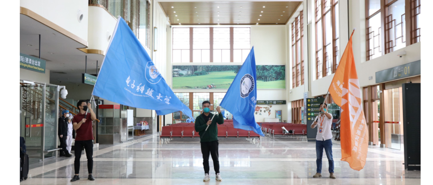Some of the students of Glasgow College Hainan UESTC waving flags at the airport