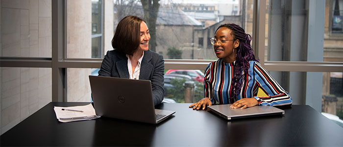 Staff member talking to a student in the Fraser Building