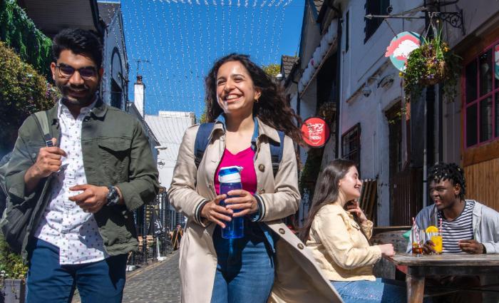 Four students in Ashton Lane on a sunny day