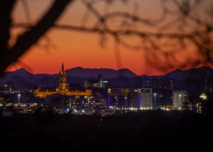 Gilbert Scott building and Glasgow skyline at sunset