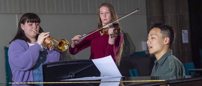 3 music students in the concert hall practising