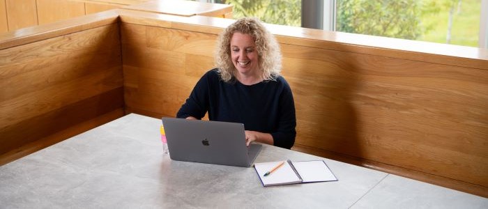image of person sitting behind an apple laptop