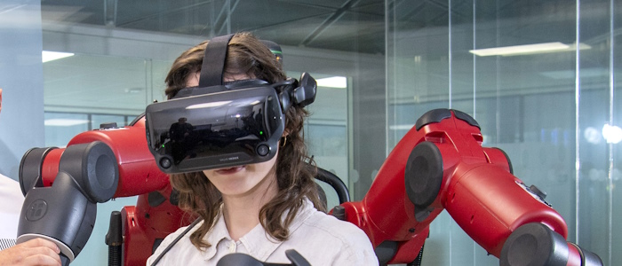 A student with VR headset and robotic arms