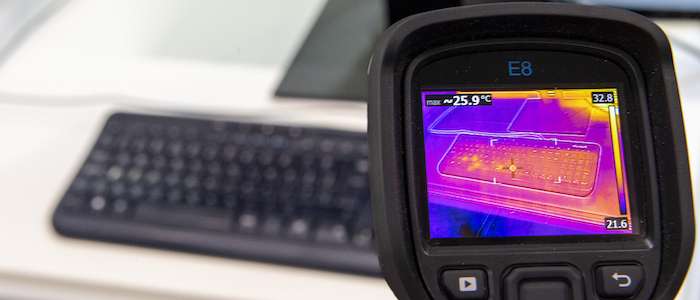 A picture of a thermal camera showing traces of heat on a computer keyboard